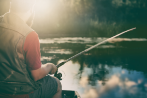 Angeln in und um St. Andreasberg. Ein Mann hält eine Angel in den See