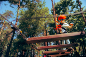 Kletterpark in St. Andreasberg. Kind mit Helm klettert