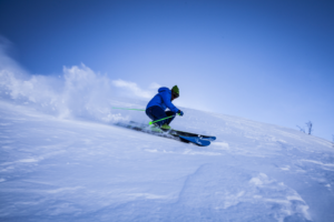 Skigebiet Matthias Schmidt Berg. Ein Skifahrer fährt die Piste seitlich runter