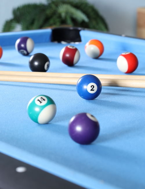 Blauer Billiardtisch mit Kugeln und zwei Schlägern