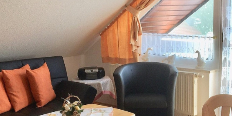Wohnzimmer mit schwarzem Sofa und Sessel, Wohnzimmertisch Dachgeschoss